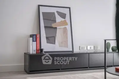 Modern living room with sleek black console and abstract art decor