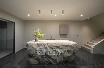 Modern minimalist kitchen with unique stone island and sleek lighting