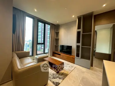 Modern living room with large windows, stylish furniture, and a sleek entertainment center in a high-rise apartment.