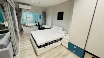 Modern bedroom with sleek design, featuring a comfortable bed, study desk, and large window for natural light.