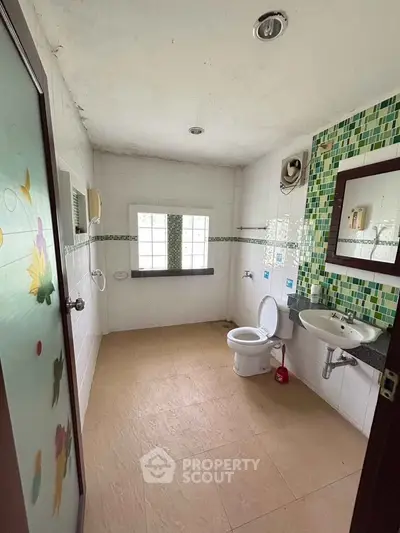 Spacious bathroom with modern fixtures and colorful tile accents, ideal for a refreshing start to your day.