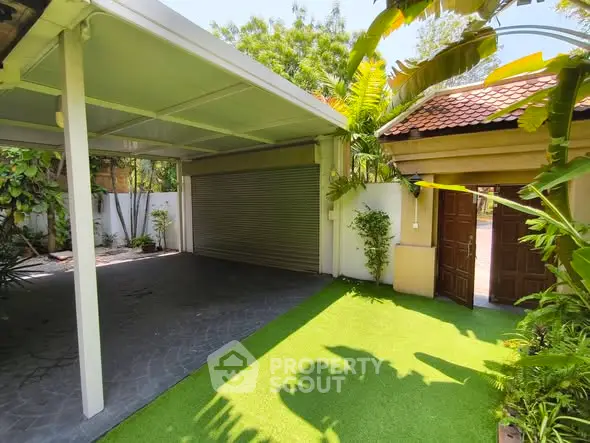 Spacious covered parking area with lush greenery and secure entrance in a serene residential setting.