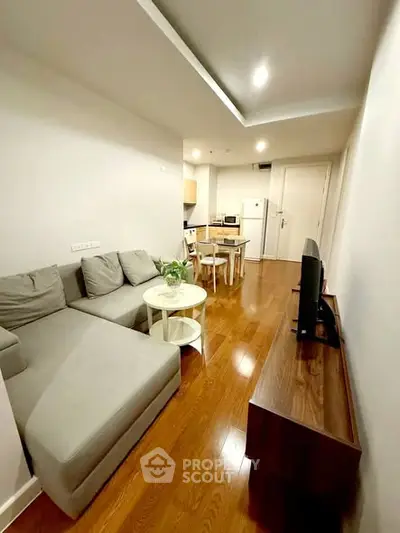 Modern living room with cozy gray sofa and sleek wooden flooring