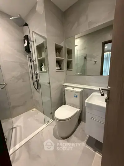 Modern bathroom with glass shower and sleek fixtures in contemporary apartment
