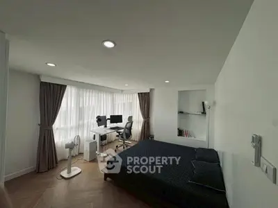 Modern bedroom with workspace, featuring large windows and elegant curtains.