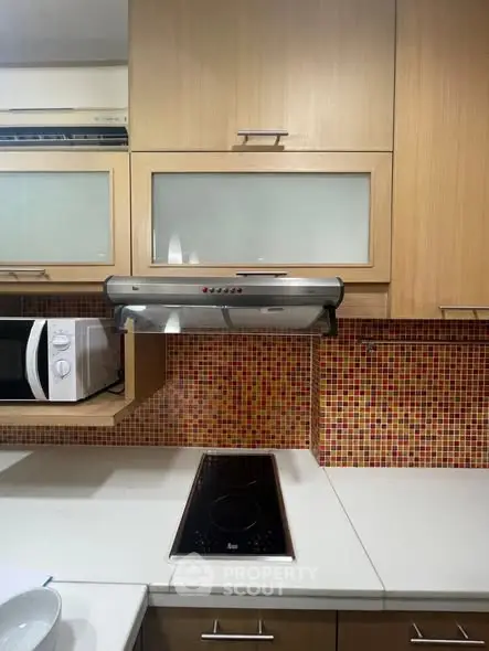 Modern kitchen with sleek appliances and mosaic backsplash