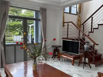 Elegant living room with stylish staircase and large window view.