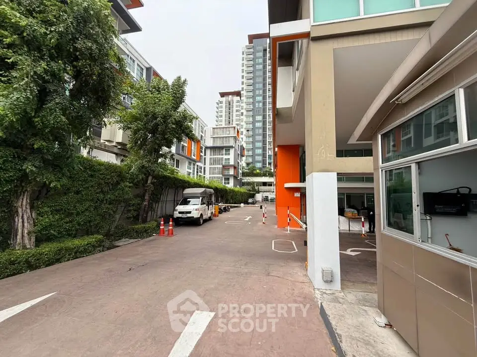 Modern residential building exterior with driveway and lush greenery