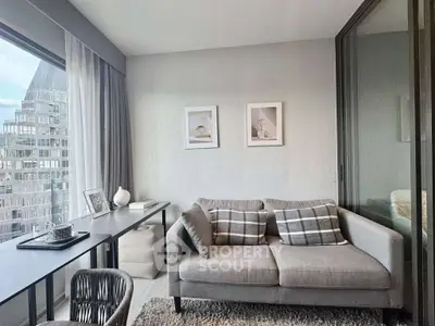 Modern living room with stylish decor and city view, featuring a cozy sofa and sleek desk.