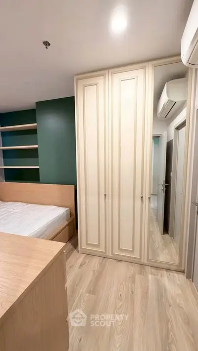 Modern bedroom with built-in wardrobe and wooden flooring
