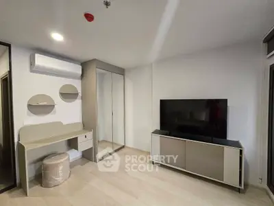 Modern living room with sleek furniture and large TV, featuring minimalist design and neutral tones.