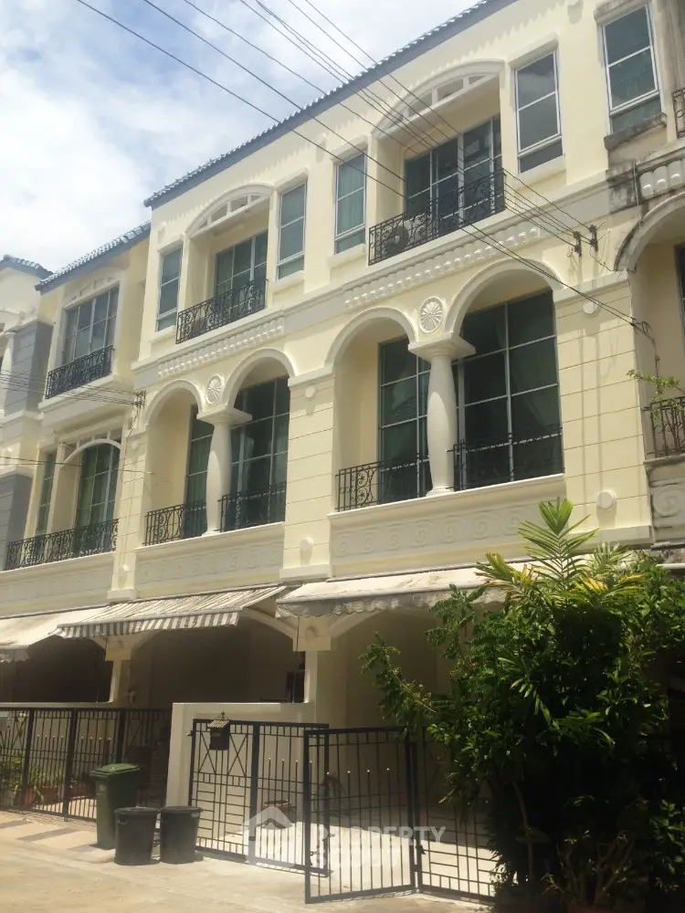 Elegant three-story townhouse with classic architecture and gated entrance