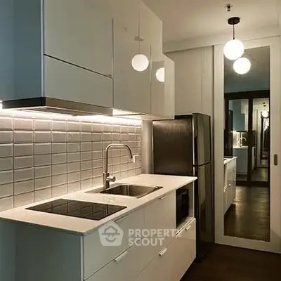 Modern kitchen with sleek cabinetry and stainless steel appliances in a stylish apartment.