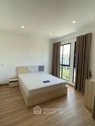 Spacious bedroom with large window and modern decor