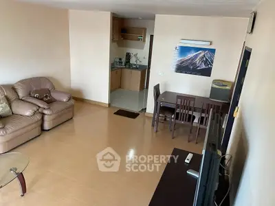 Spacious living room with cozy seating and open kitchen layout in modern apartment.