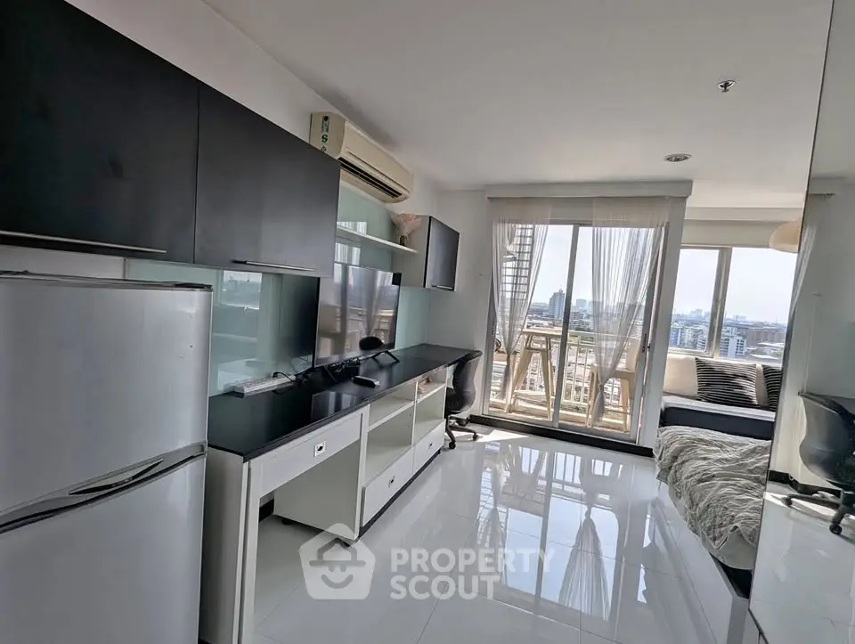 Modern apartment with sleek kitchen and city view balcony, perfect for urban living.