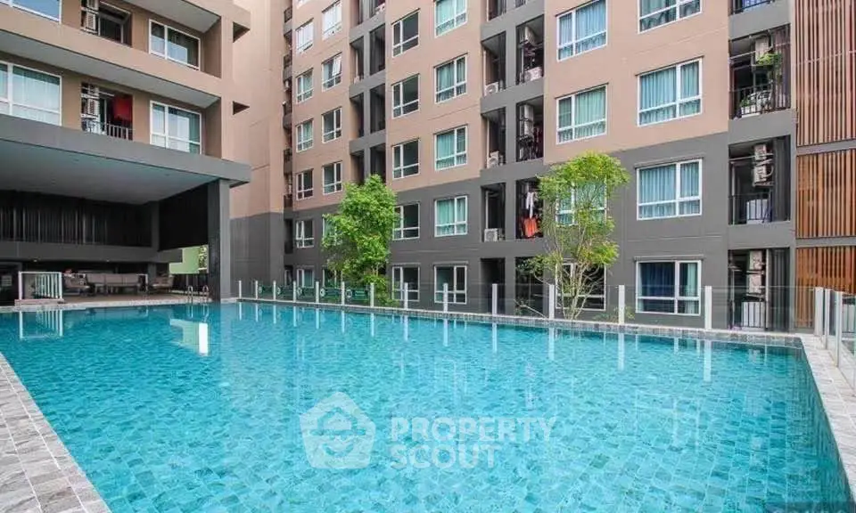 Modern apartment complex with a spacious swimming pool and stylish architecture.