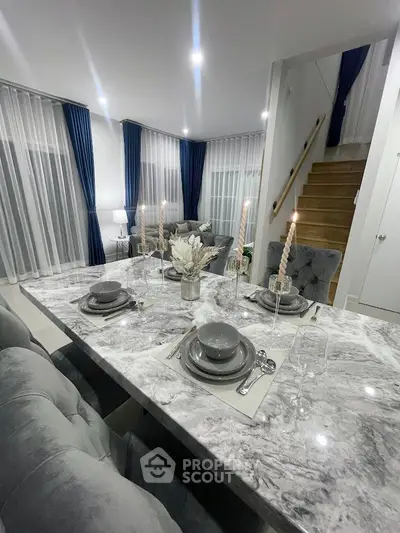 Luxurious dining area with elegant marble table and plush seating in modern home