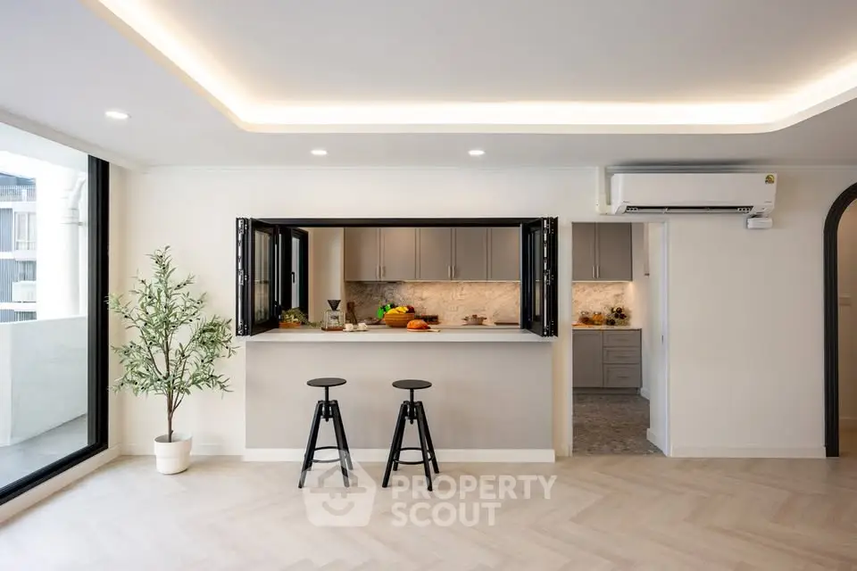 Modern open-plan kitchen with sleek design and breakfast bar in stylish apartment
