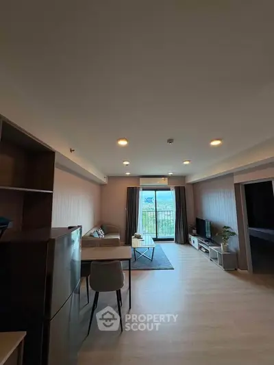 Spacious modern living room with balcony and scenic view, perfect for urban living.