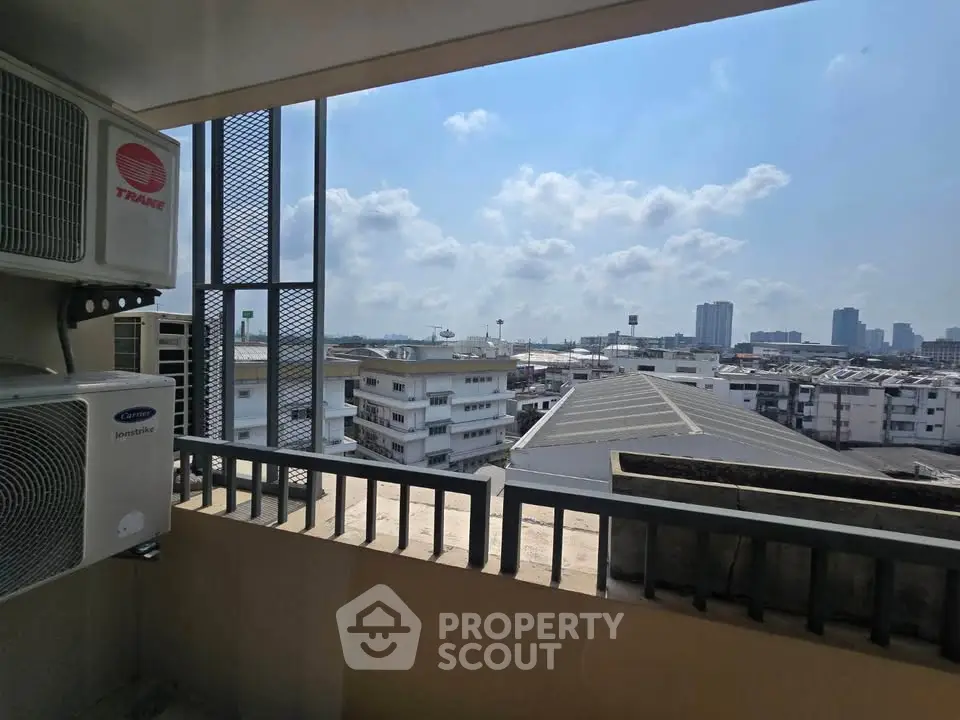 Stunning cityscape view from a high-rise balcony with air conditioning units.