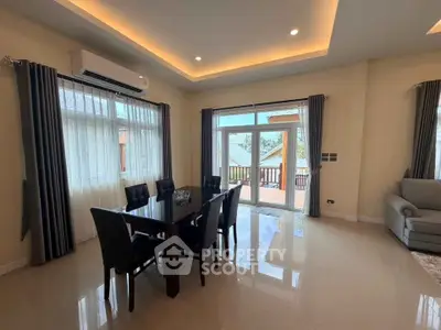 Spacious living room with elegant dining area and large windows leading to a balcony.