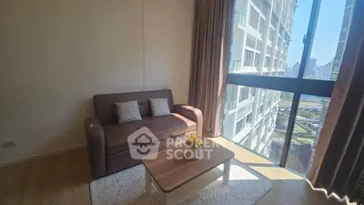 Bright living room with cozy sofa and stunning city view from large window.