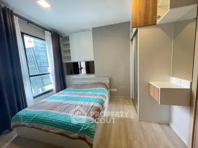 Modern bedroom with large window and stylish furnishings in urban apartment