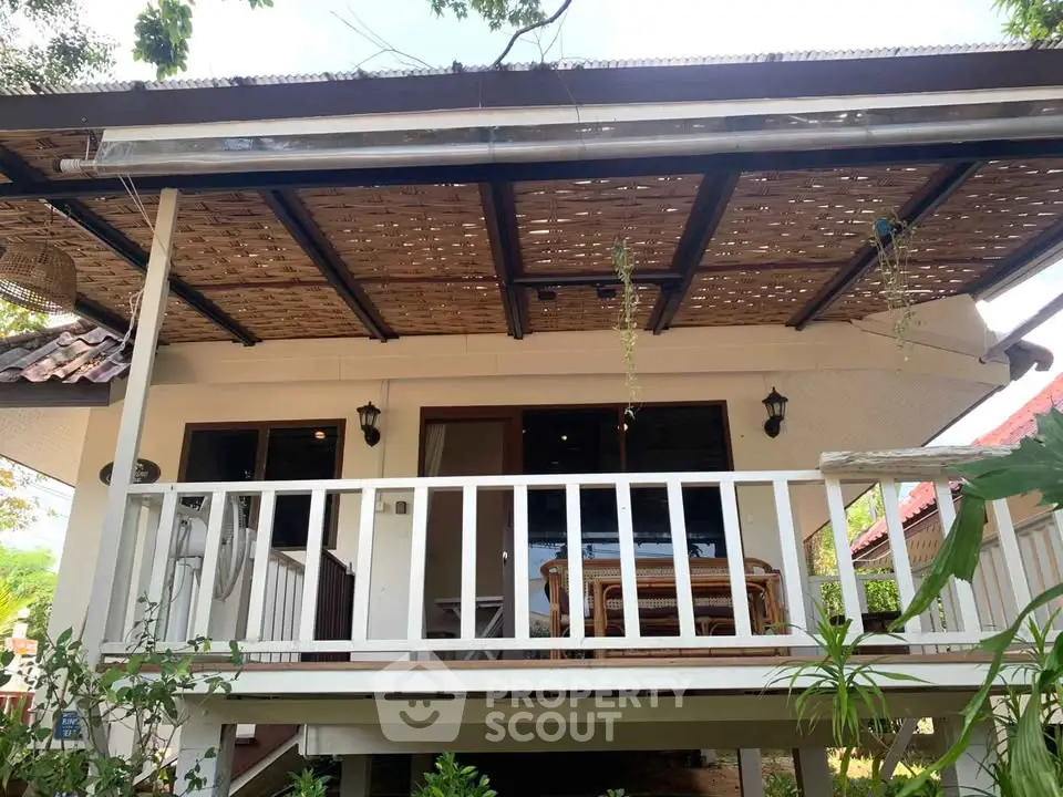 Charming bungalow with inviting porch and lush greenery, perfect for tranquil living.