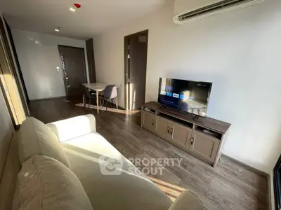 Modern living room with sleek furniture and natural light, featuring a cozy sofa and wall-mounted TV.
