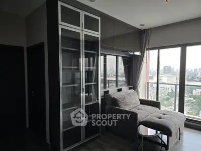 Modern living room with city view, featuring sleek glass cabinet and cozy seating area.