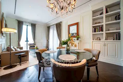 Elegant living and dining area with chandelier and built-in bookshelves in luxury apartment.