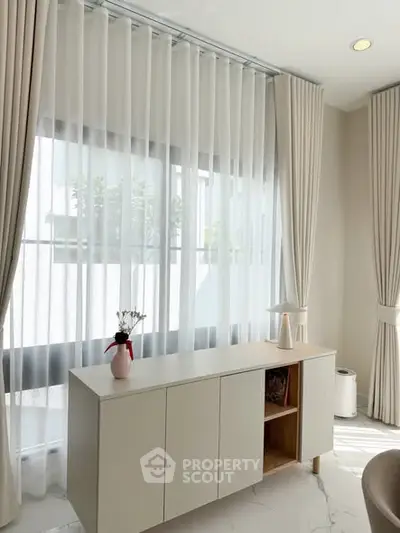 Bright and elegant living room with large windows and modern decor