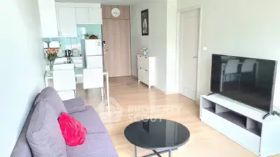 Modern living room with stylish furniture and open kitchen layout in a cozy apartment.