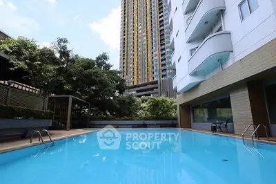Luxurious residential building with a stunning outdoor pool and modern architecture.
