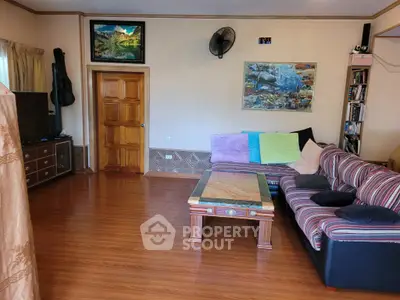 Spacious living room with stylish decor and cozy seating area, perfect for relaxation and entertainment.