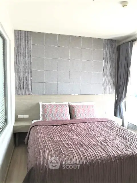 Modern bedroom with stylish decor and large windows for natural light.