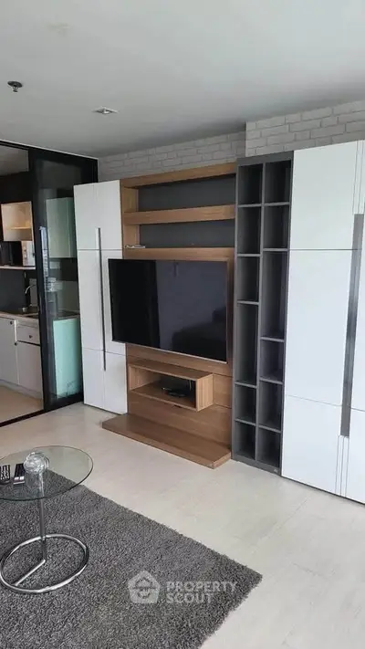 Modern living room with sleek entertainment center and glass coffee table