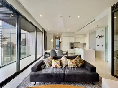 Luxurious modern living room with floor-to-ceiling windows and sleek open kitchen design.