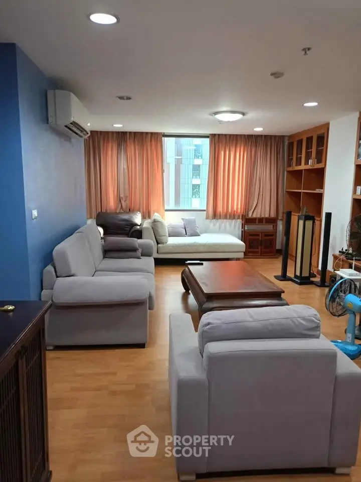 Spacious living room with modern furniture and large window view.