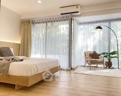 Spacious bedroom with floor-to-ceiling windows and modern decor