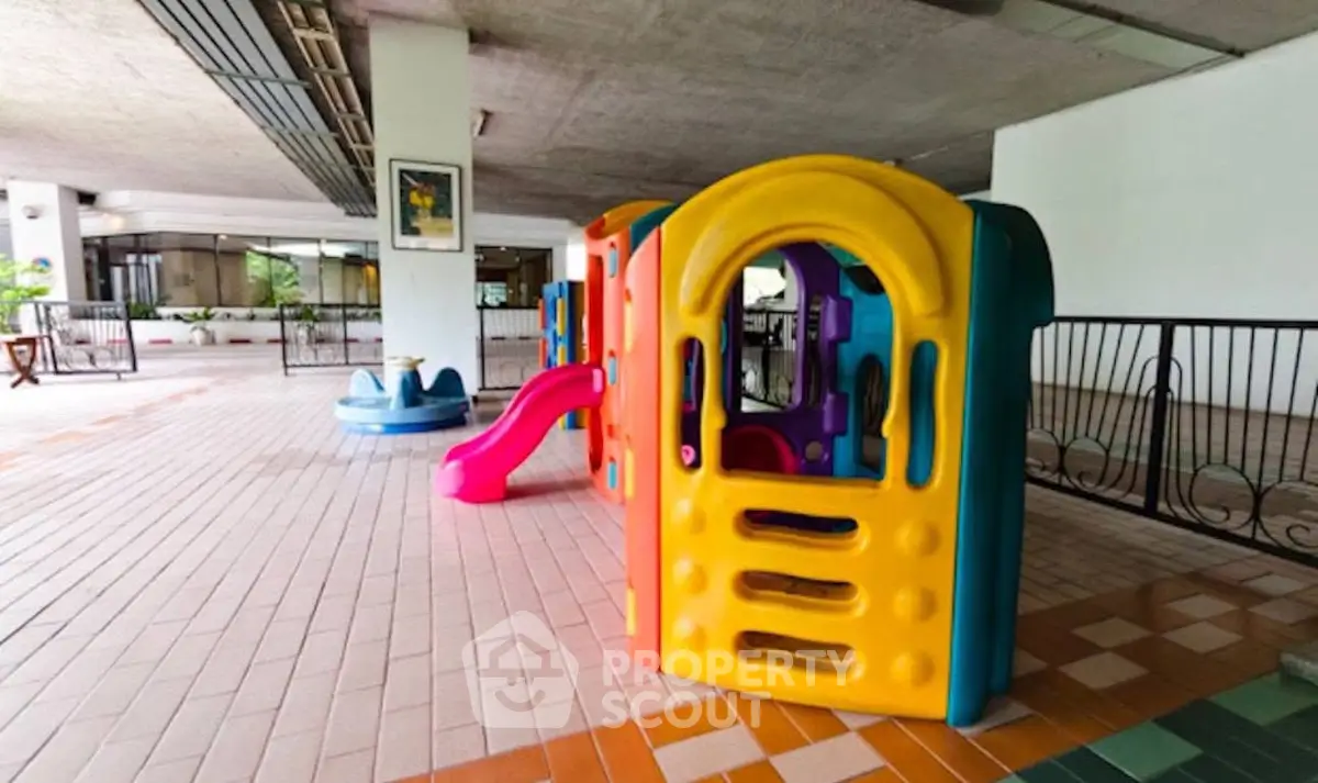 Spacious covered play area with colorful children's playhouse in modern building.