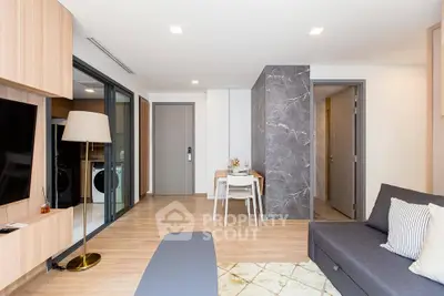 Modern living room with open layout, stylish decor, and natural light, featuring a cozy seating area and dining space.