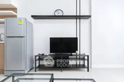 Modern living room with sleek TV stand and stainless steel fridge, minimalist design.