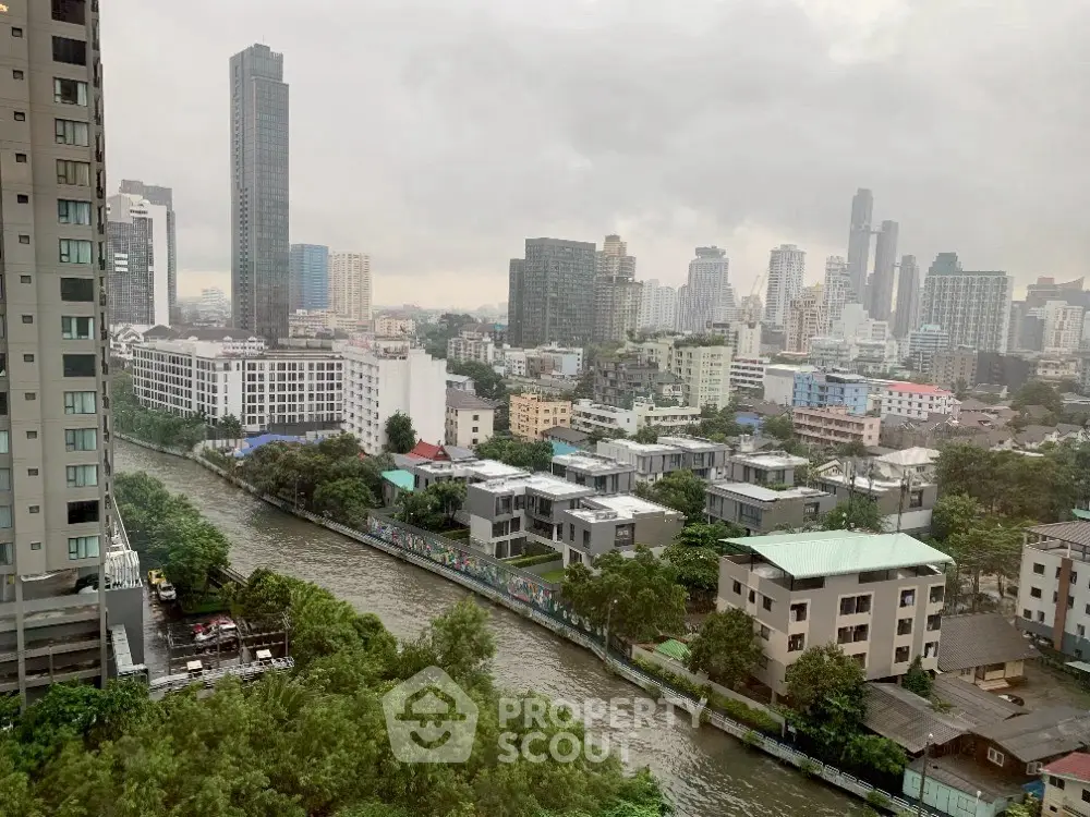 Stunning cityscape view from high-rise apartment overlooking river and skyline.