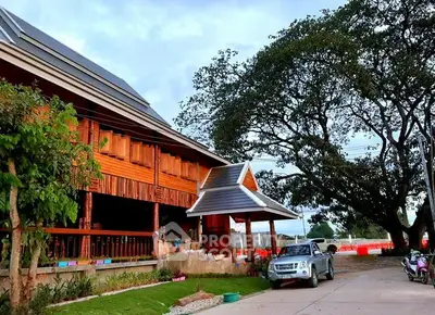 Charming wooden house with spacious driveway and lush greenery, perfect for serene living.