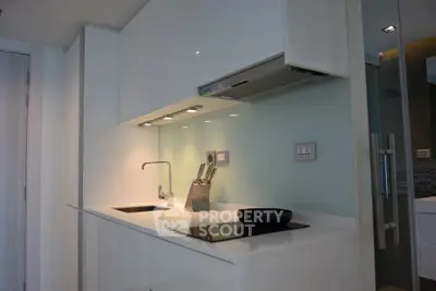 Sleek modern kitchen with white cabinetry and induction cooktop