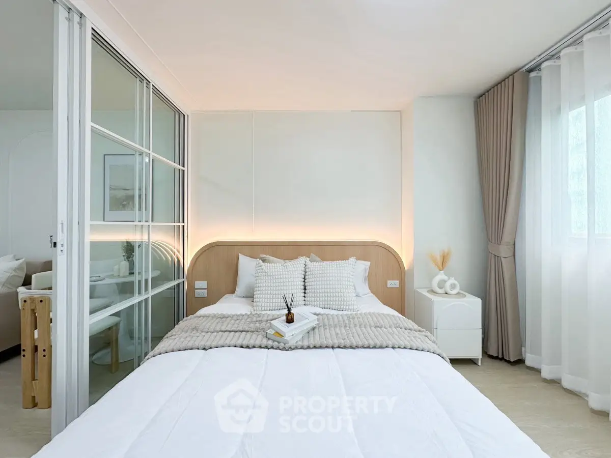 Modern bedroom with cozy decor and natural light, featuring a stylish bed and elegant curtains.