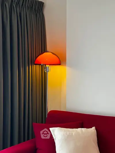 Stylish living room corner with vibrant red sofa and modern floor lamp