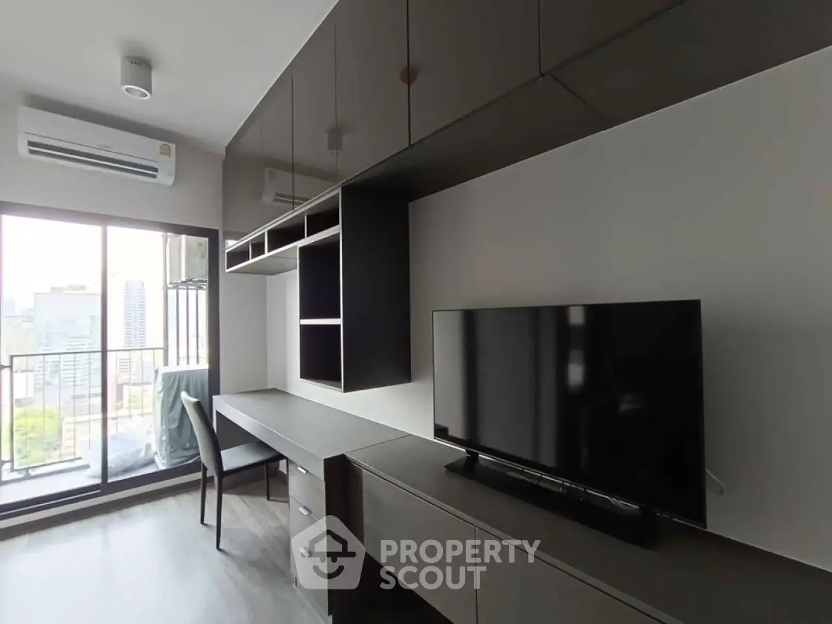 Modern living room with sleek furniture and city view balcony in high-rise apartment.